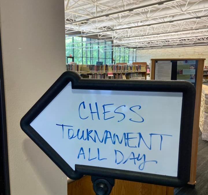White arrow sign that reads chess tournament all day